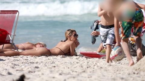 Danielle Winits mostra corpo ao se bronzear na praia
