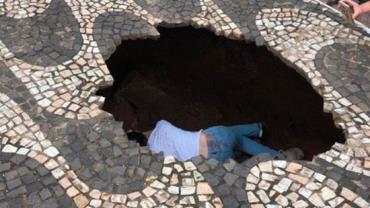 Vídeo: Jovem é engolida por cratera em calçada de Minas Gerais