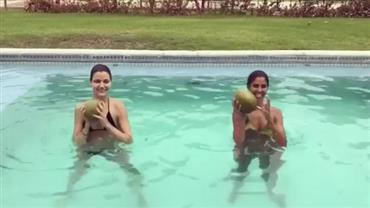 Bela Gil faz malhação na piscina usando cocos como pesos
