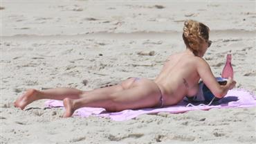 Aos 45 anos, atriz Rita Guedes faz topless na praia da Barra da Tijuca