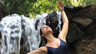 Aos 46 anos, Letícia Spiller usa maiô com recorte estratégico em banho de cachoeira